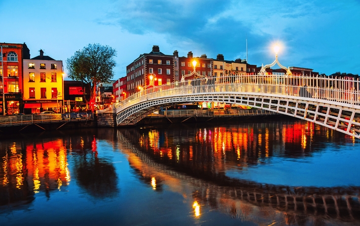 Nachtansicht der berühmten Ha’penny Bridge in Dublin bei Sonnenuntergang, Irland 